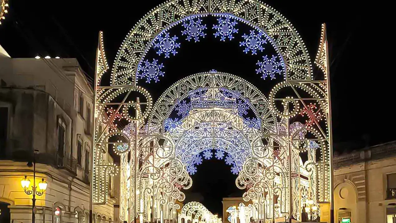 Archi luminosi illuminano la notte di Galatina per la festa di San Pietro e Paolo, creando un'atmosfera magica.
