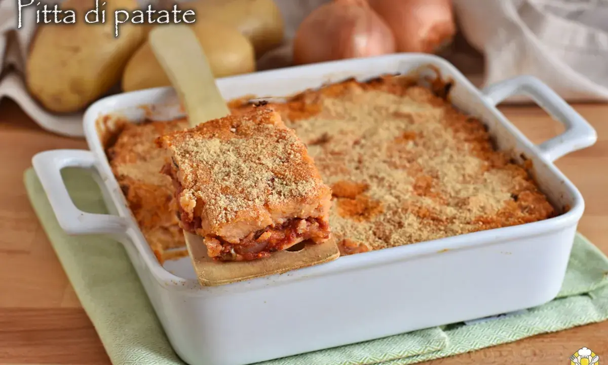 Una fetta di focaccia di patate ripiena pugliese dorata e croccante, servita da una teglia bianca.