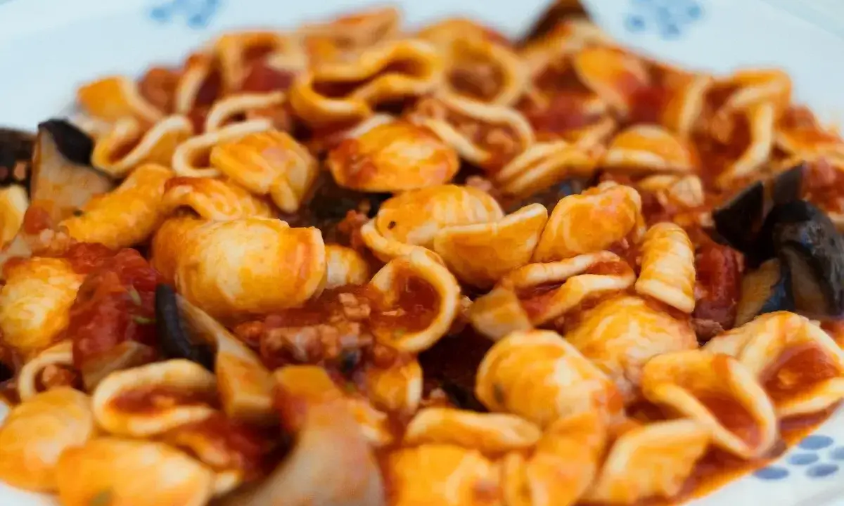 Orecchiette alla tarantina con melanzane e pomodoro, un piatto ricco e saporito.