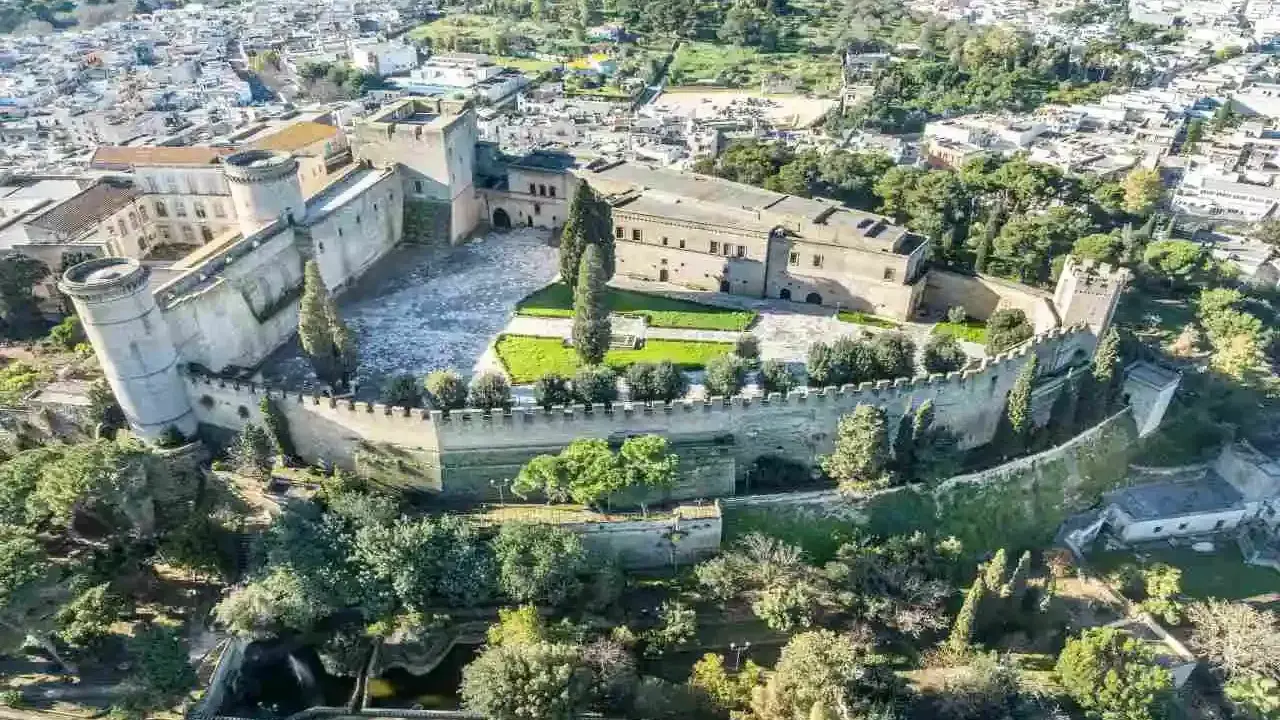 Castello normanno con torri rotonde e mura merlate, ideale per scoprire dove andare a Pasquetta in Puglia, circondato da verde e un borgo.