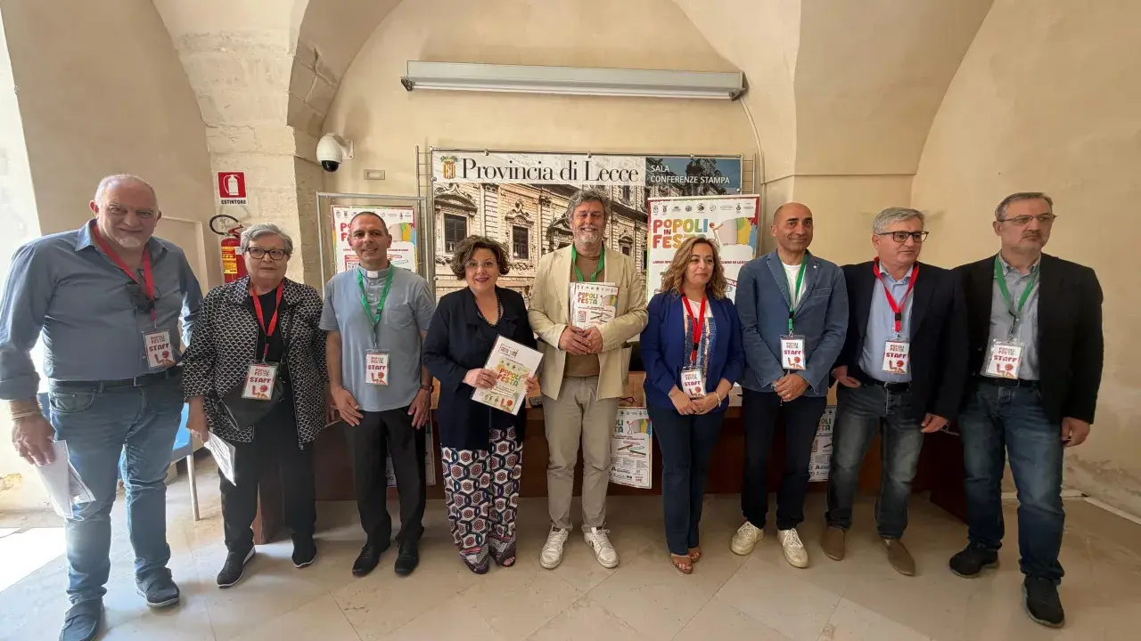 Gruppo di persone sorridenti, staff di "Popoli in Festa", durante eventi nel Salento.