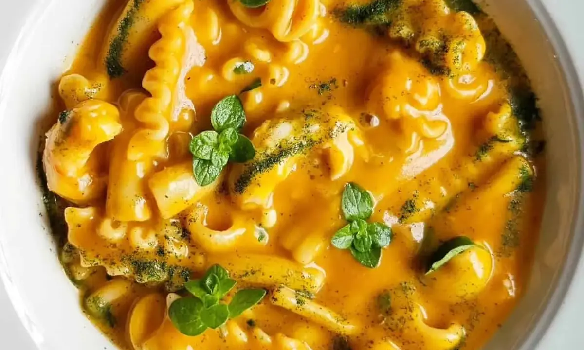 Un piatto di pasta cremosa, uno dei sapori dei ristoranti tipici pugliesi, guarnito con erbe fresche.