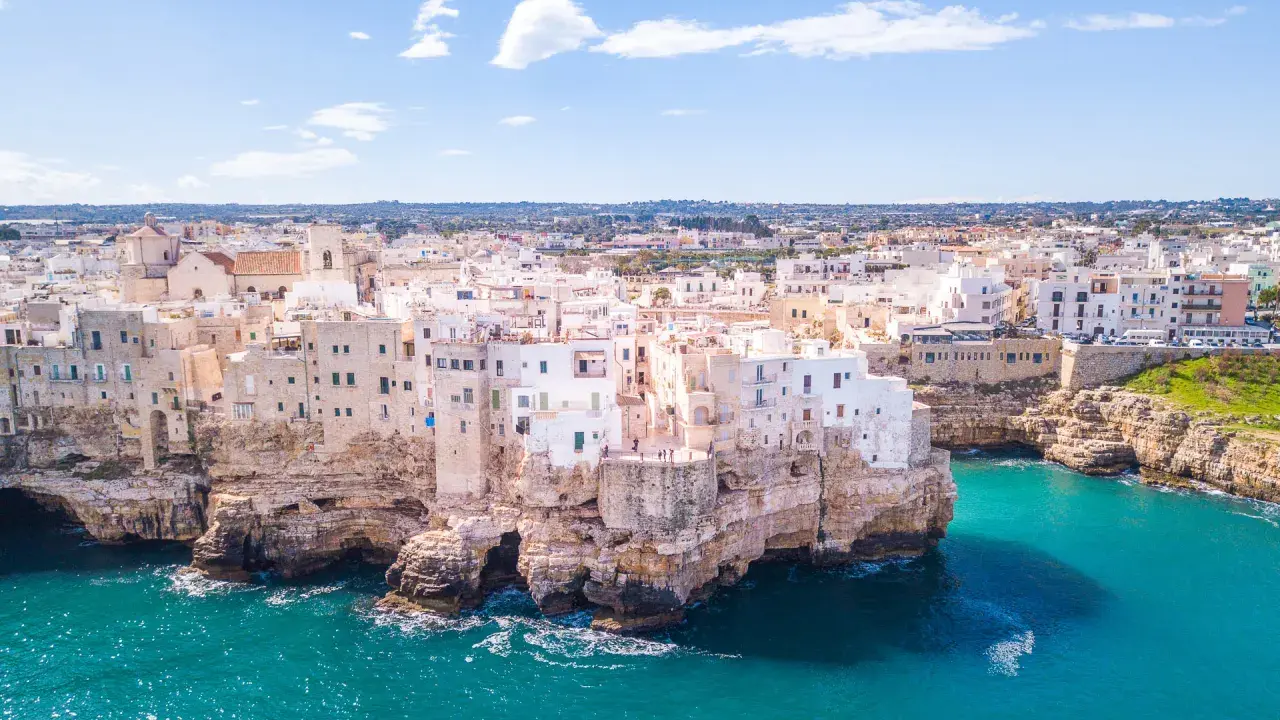 Panorami mozzafiato: case bianche aggrappate alle scogliere, mare turchese. Un assaggio di cosa vedere in Puglia, un sogno ad occhi aperti.