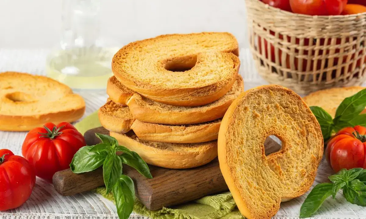 Fette dorate di pane tipico pugliese, con pomodori freschi e basilico, pronte per essere gustate.