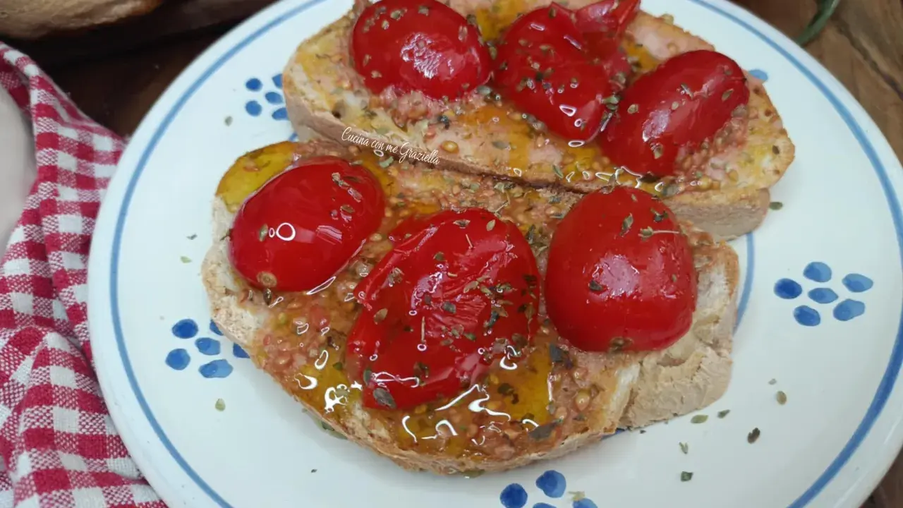 Pane e pomodoro, un assaggio dei campi salentini. Bruschette condite con pomodorini freschi, olio d'oliva e origano, su un piatto decorato.