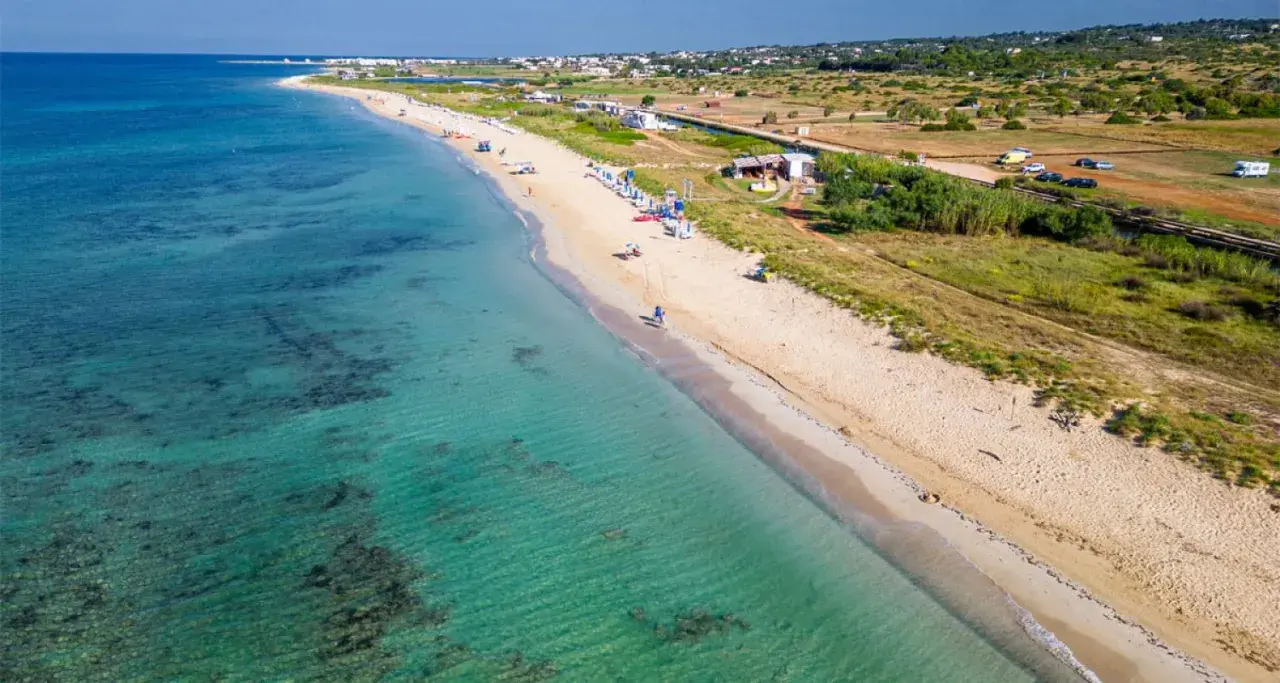 Spiaggia di Torre Vado, Pescoluse, con acque cristalline e sabbia dorata. Un luogo ideale per rilassarsi e godersi il sole.