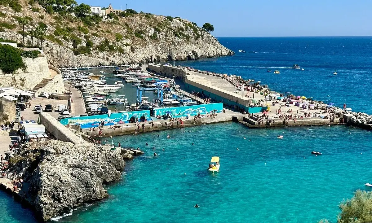 Un'estate a Castro: gente in spiaggia, barche nel porto e acque cristalline. Perfetto per scoprire cosa fare a Castro.