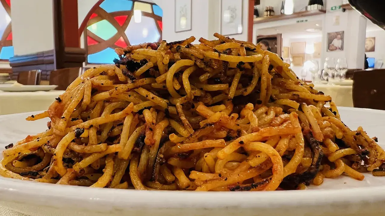 Un piatto di spaghetti con pomodoro e verdure, un assaggio di cosa si mangia a Bari.