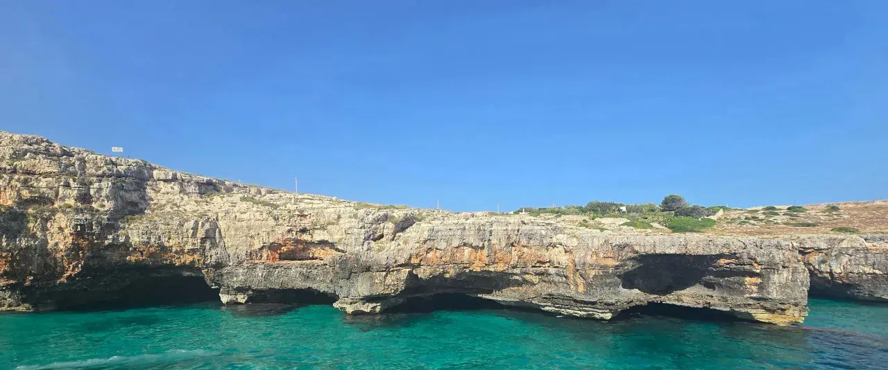 Scogliere rocciose e mare cristallino, un invito a esplorare le **grotte del Salento**.