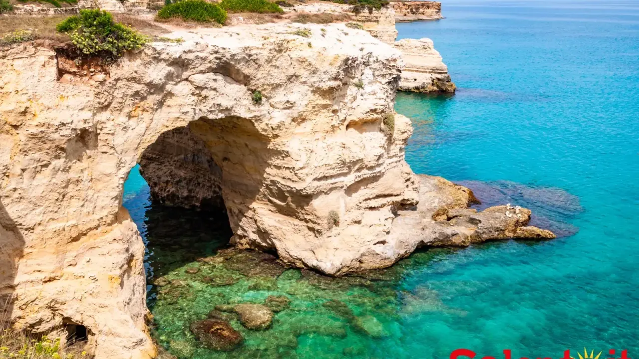 Scogliere dorate e mare cristallino, un'incantevole grotta marina. Perfetto per un Ferragosto Salento indimenticabile.