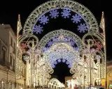 Archi luminosi illuminano la notte di Galatina per la festa di San Pietro e Paolo, creando un'atmosfera magica.