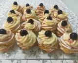 Zeppole pugliesi, dolci fritti con crema pasticcera e ciliegina, spolverati di zucchero a velo.