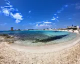 Spiaggia incantevole nel Salento ionico, con acque cristalline, sabbia dorata e un'antica torre di avvistamento.