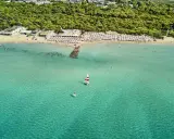 Spiaggia affollata con ombrelloni e mare cristallino a Marina di Ugento, dove si trova questo paradiso.