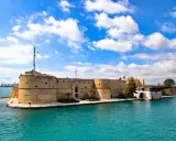 Castello Aragonese a Taranto, un gioiello che mostra dove si trova la Puglia, con il mare turchese e il cielo azzurro.