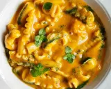 Un piatto di pasta cremosa, uno dei sapori dei ristoranti tipici pugliesi, guarnito con erbe fresche.