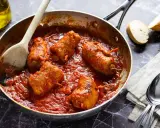 Braciola pugliese in padella con sugo rosso, pronte per essere gustate con pane fresco.