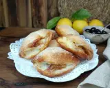 Monachine salentine dorate e zuccherate, un dolce profumato con ripieno di mele e un tocco di ciliegie.