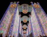 Un paese delle luminarie puglia incantato, con archi maestosi e decorazioni floreali di luci colorate che creano un tunnel magico nella notte.