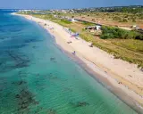 Spiaggia di Torre Vado, Pescoluse, con acque cristalline e sabbia dorata. Un luogo ideale per rilassarsi e godersi il sole.