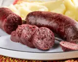 Sanguinaccio pugliese affettato e intero, servito con purè di patate. Un sapore autentico della tradizione.