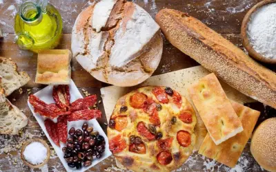 Pane, focaccia, pomodori secchi e olive: un assaggio dei piatti tipici pugliesi, con olio d'oliva e sale.