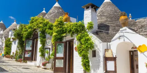Trulli bianchi fioriti in Puglia, un'atmosfera magica per il 25 aprile.