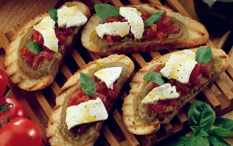 Bruschetta supersano con melanzane, pomodori e mozzarella fresca, guarnita con basilico e un filo d'olio.