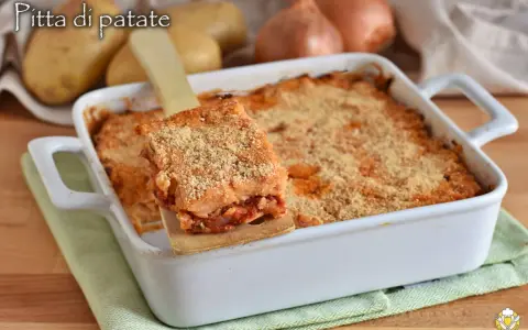 Una fetta di focaccia di patate ripiena pugliese dorata e croccante, servita da una teglia bianca.