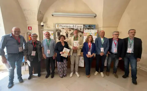 Gruppo di persone sorridenti, staff di "Popoli in Festa", durante eventi nel Salento.