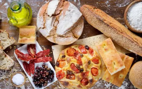 Pane, focaccia, pomodori secchi e olive: un assaggio dei piatti tipici pugliesi, con olio d'oliva e sale.