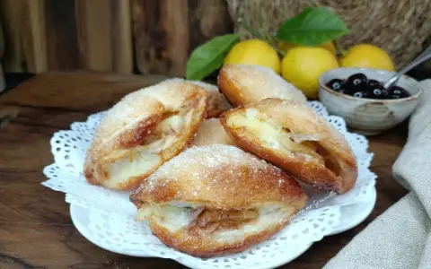 Monachine salentine dorate e zuccherate, un dolce profumato con ripieno di mele e un tocco di ciliegie.
