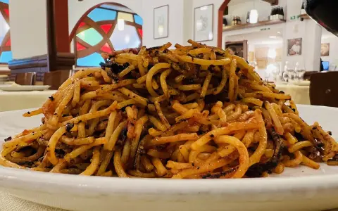 Un piatto di spaghetti con pomodoro e verdure, un assaggio di cosa si mangia a Bari.