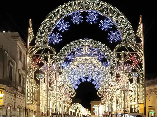 Archi luminosi illuminano la notte di Galatina per la festa di San Pietro e Paolo, creando un'atmosfera magica.