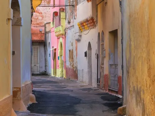 Un vicolo colorato a Galatone, con case rosa, gialle e bianche. Un luogo incantevole da scoprire, tra scorci suggestivi e architetture uniche.