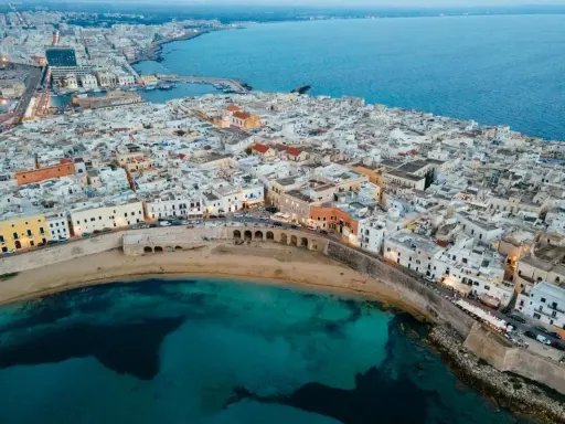 Vista aerea di Gallipoli, con le sue case bianche affacciate sul mare turchese. Immagina le feste estive e la vivacità di questa perla salentina.