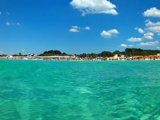 Acque cristalline e una spiaggia affollata di ombrelloni colorati: il **miglior lido Torre Lapillo** per una giornata di sole indimenticabile.