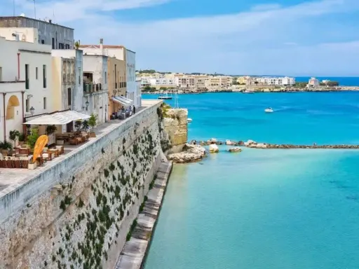 Vista panoramica del centro storico di Otranto, con case bianche affacciate sul mare turchese. Una mappa ideale per esplorare questo gioiello pugliese.
