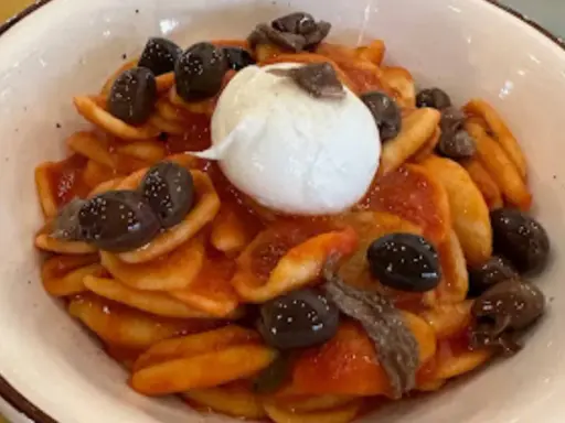 Orecchiette con pomodoro, olive nere, acciughe e burrata, un assaggio dei piatti tipici tarantini.