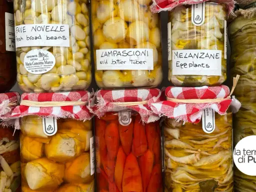 Vasi di **piatti tipici pugliesi** conservati: fave novelle, lampascioni, melanzane e altro. Sapori autentici in ogni barattolo.