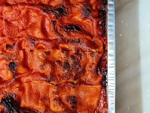 La lasagna salentina appena sfornata, con la sua crosticina dorata e invitante, pronta per essere gustata.
