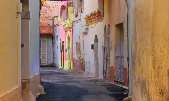 Un vicolo colorato a Galatone, con case rosa, gialle e bianche. Un luogo incantevole da scoprire, tra scorci suggestivi e architetture uniche.