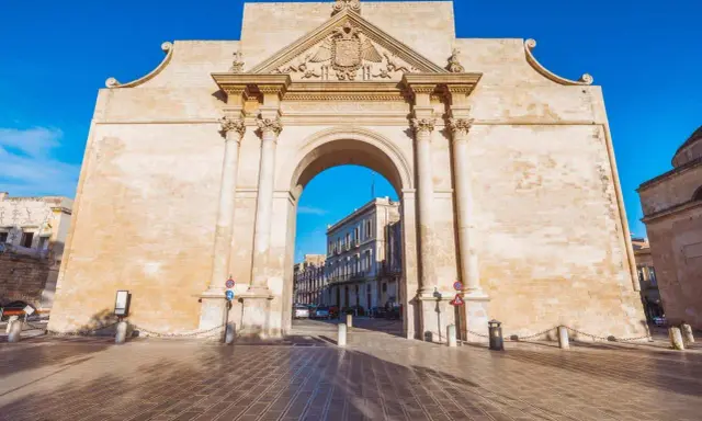 Porta Napoli, un arco trionfale in pietra leccese, invita a scoprire le cose da fare a Lecce. Un'antica porta che segna l'ingresso alla città barocca.