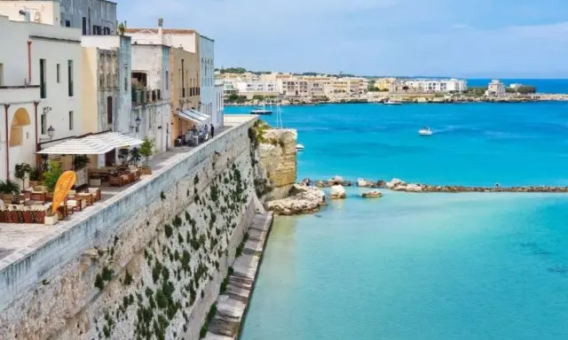 Vista panoramica del centro storico di Otranto, con case bianche affacciate sul mare turchese. Una mappa ideale per esplorare questo gioiello pugliese.