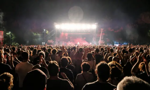 Folla entusiasta ai concerti Salento, luci sul palco e musica dal vivo.