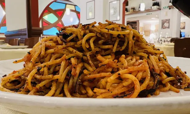 Un piatto di spaghetti con pomodoro e verdure, un assaggio di cosa si mangia a Bari.