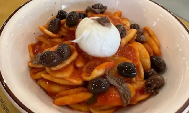 Orecchiette con pomodoro, olive nere, acciughe e burrata, un assaggio dei piatti tipici tarantini.