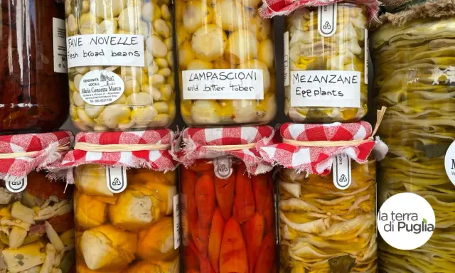 Vasi di **piatti tipici pugliesi** conservati: fave novelle, lampascioni, melanzane e altro. Sapori autentici in ogni barattolo.