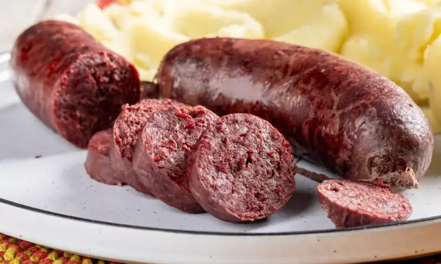 Sanguinaccio pugliese affettato e intero, servito con purè di patate. Un sapore autentico della tradizione.