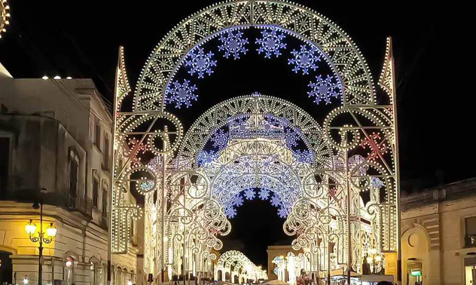 Archi luminosi illuminano la notte di Galatina per la festa di San Pietro e Paolo, creando un'atmosfera magica.